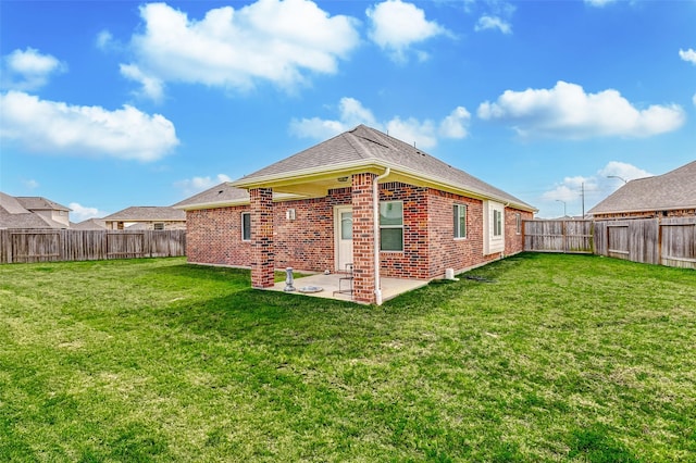 back of property with a yard, a patio, brick siding, and a fenced backyard