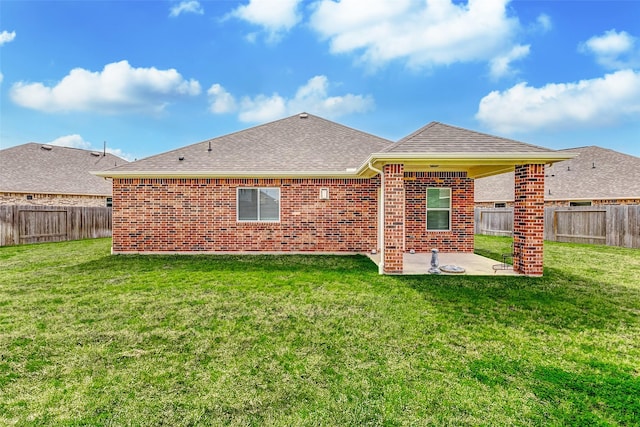 back of property featuring a yard, brick siding, a patio area, and a fenced backyard