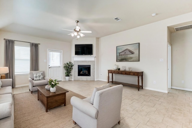 living area with baseboards, visible vents, ceiling fan, and a fireplace