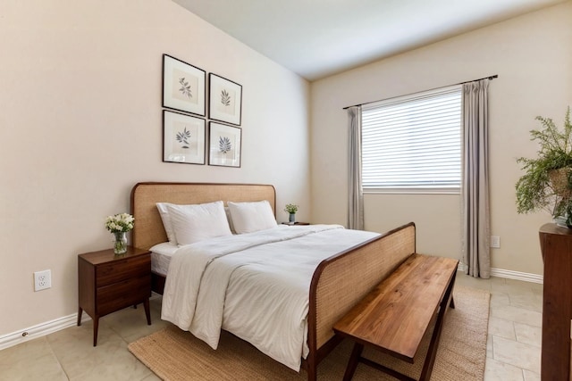 bedroom with light tile patterned floors and baseboards