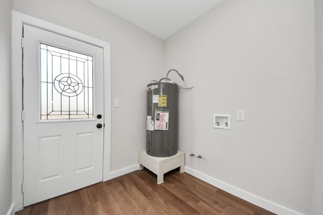 interior space featuring dark wood-type flooring, electric water heater, and baseboards