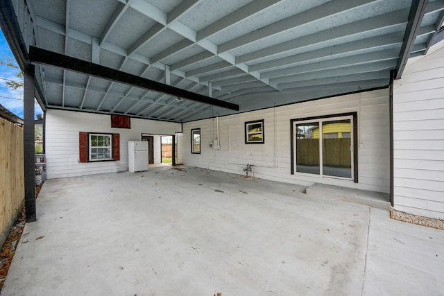 view of patio / terrace with an attached carport and fence