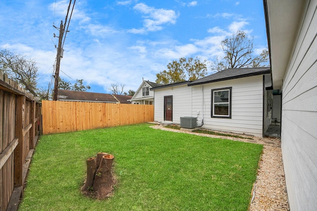 view of yard with central AC and a fenced backyard