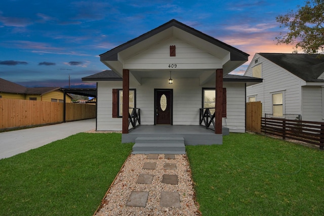 view of front of home featuring a porch, a yard, and fence