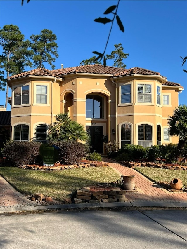 mediterranean / spanish home with a tile roof and stucco siding