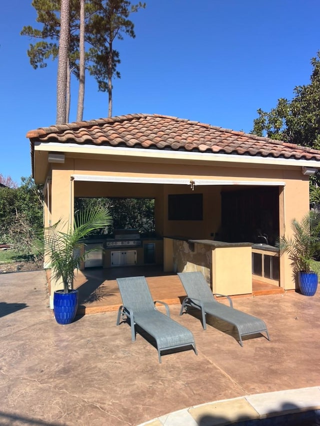 view of patio / terrace featuring outdoor wet bar, a grill, and an outdoor kitchen