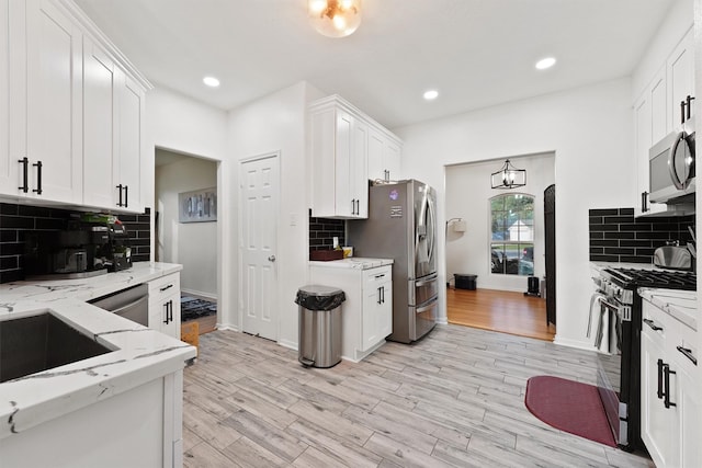 kitchen featuring light wood-type flooring, white cabinetry, and stainless steel appliances