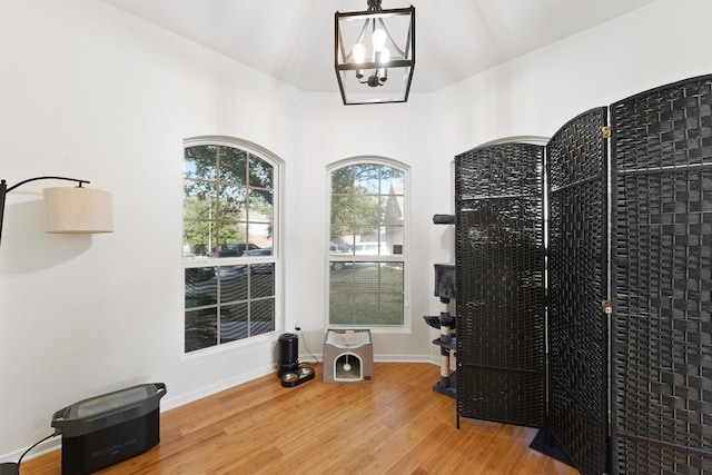 interior space featuring baseboards, an inviting chandelier, and wood finished floors