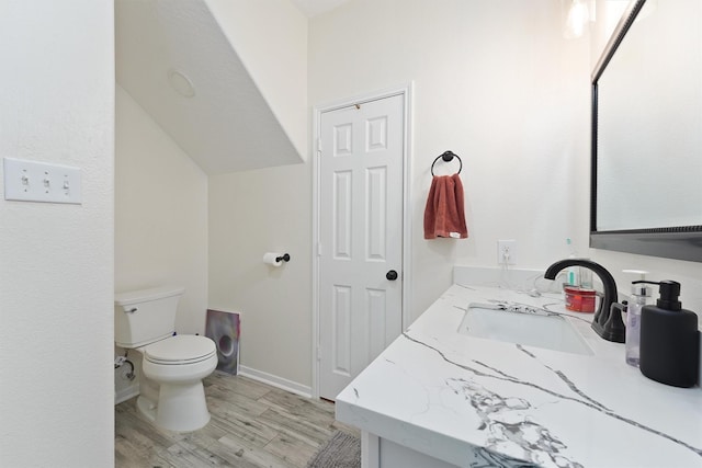 bathroom featuring baseboards, vanity, toilet, and wood finished floors