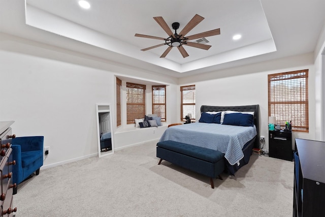 bedroom with light carpet, baseboards, a raised ceiling, and recessed lighting