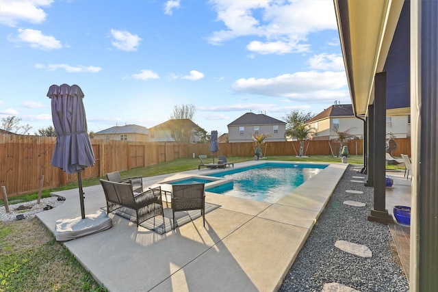 view of pool with a patio area, a fenced backyard, a pool with connected hot tub, and a lawn