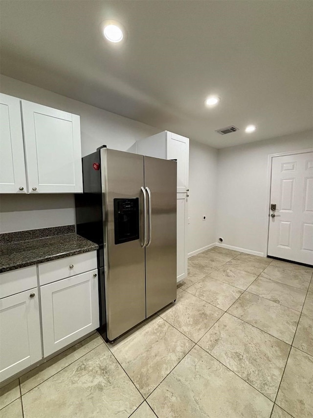 kitchen with visible vents, dark stone countertops, white cabinetry, stainless steel refrigerator with ice dispenser, and recessed lighting