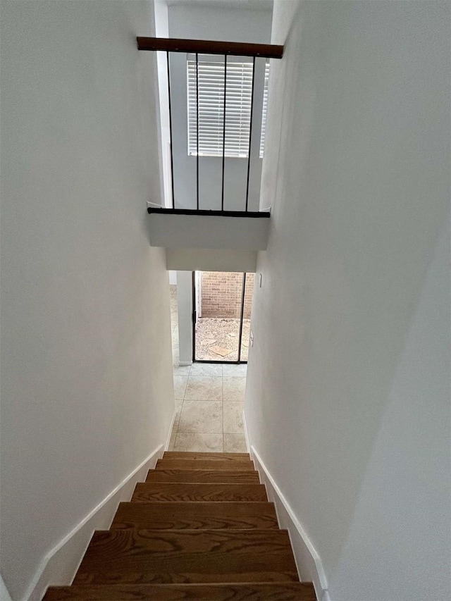 stairway with a healthy amount of sunlight and baseboards