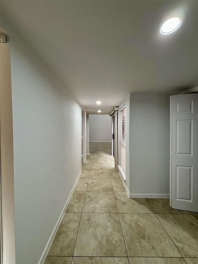 hallway featuring recessed lighting and baseboards