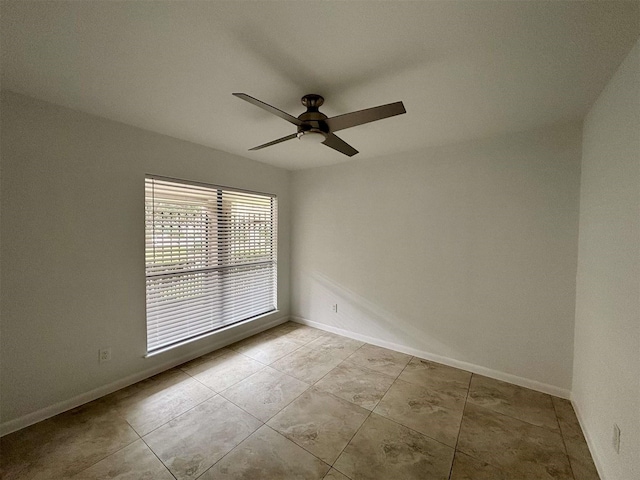 spare room featuring ceiling fan and baseboards