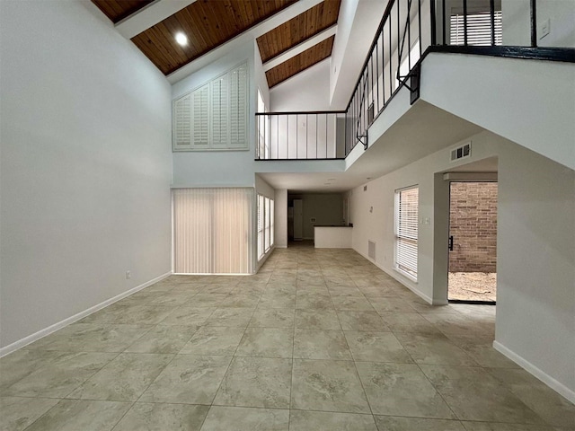 unfurnished living room featuring high vaulted ceiling, wood ceiling, visible vents, baseboards, and beam ceiling