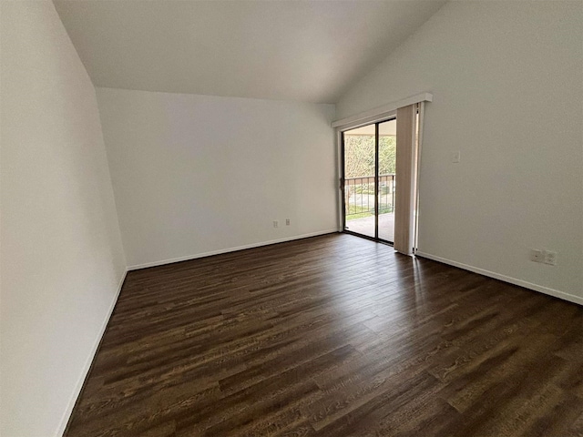 empty room featuring baseboards, vaulted ceiling, and dark wood-style flooring