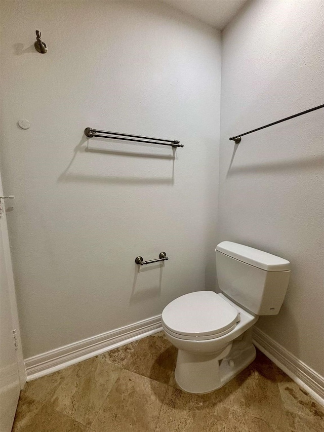 bathroom with baseboards and toilet