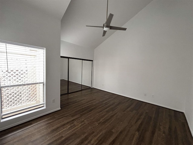 unfurnished bedroom featuring high vaulted ceiling, wood finished floors, a ceiling fan, baseboards, and a closet