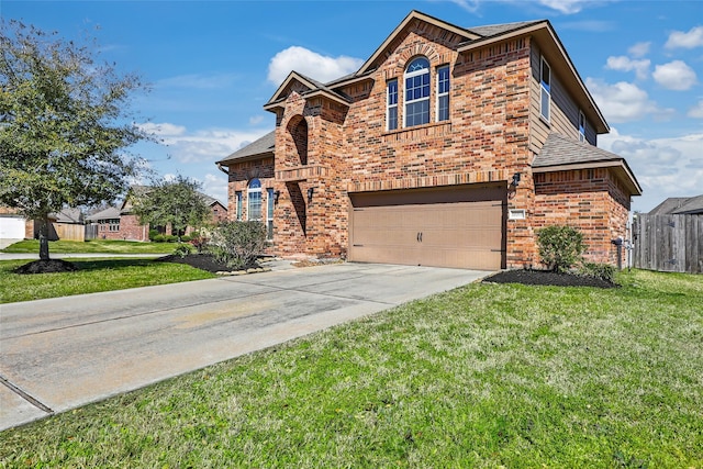 traditional-style house featuring a garage, brick siding, fence, driveway, and a front yard