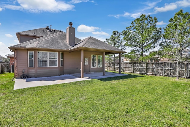 back of house featuring a patio, a lawn, a chimney, and fence