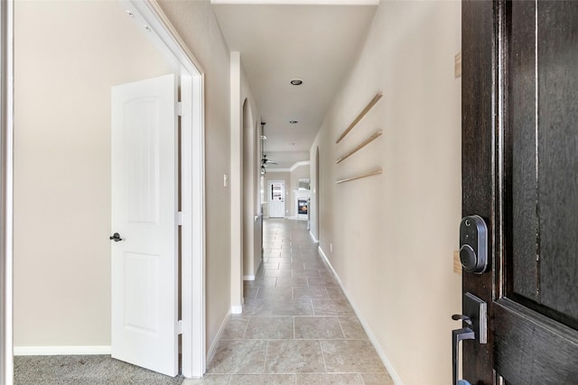 hall with baseboards and light tile patterned floors