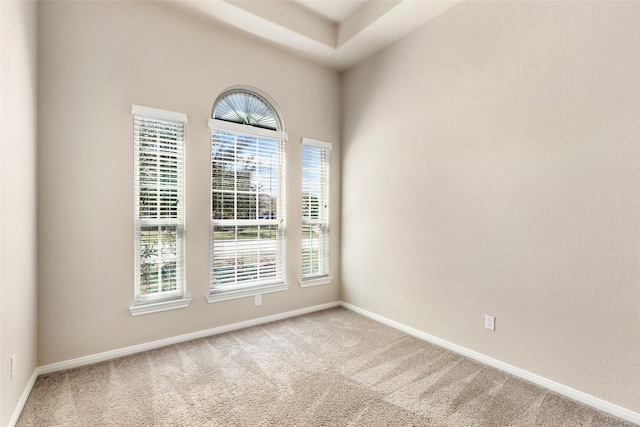 carpeted spare room featuring baseboards