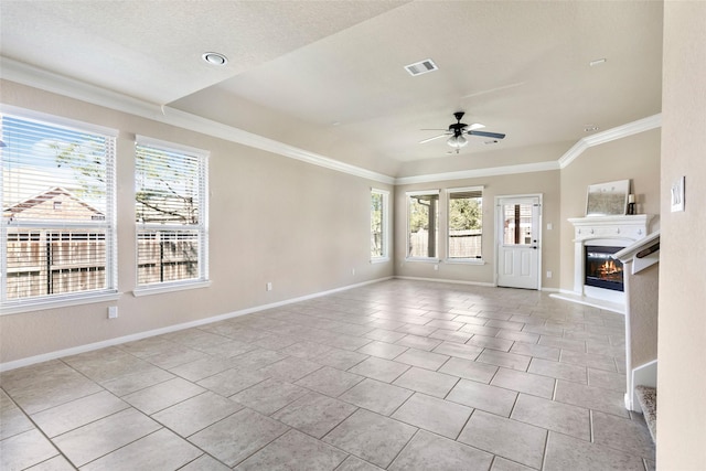 unfurnished living room featuring visible vents, a glass covered fireplace, ceiling fan, tile patterned floors, and crown molding