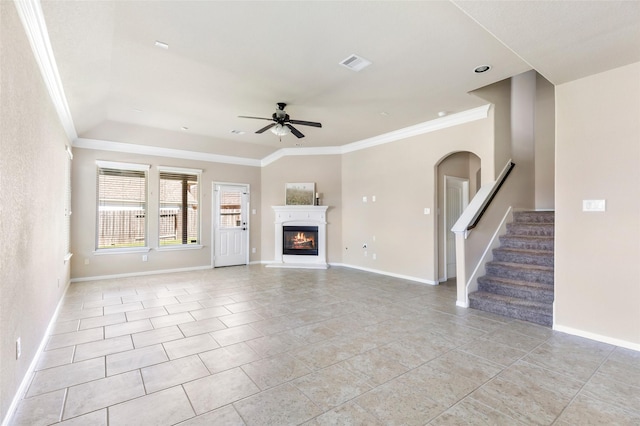 unfurnished living room with a glass covered fireplace, visible vents, crown molding, and ceiling fan