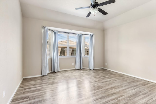 unfurnished room featuring ceiling fan, wood finished floors, and baseboards