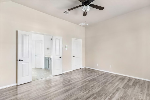 unfurnished bedroom with light wood finished floors, visible vents, ensuite bathroom, ceiling fan, and baseboards