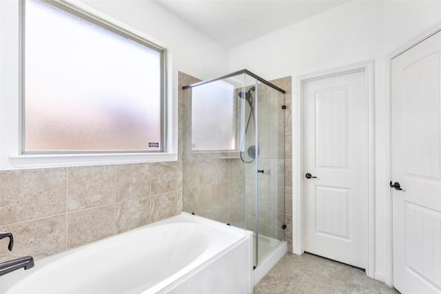 bathroom with a shower stall, a bath, and tile patterned floors