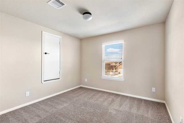 carpeted empty room with visible vents and baseboards