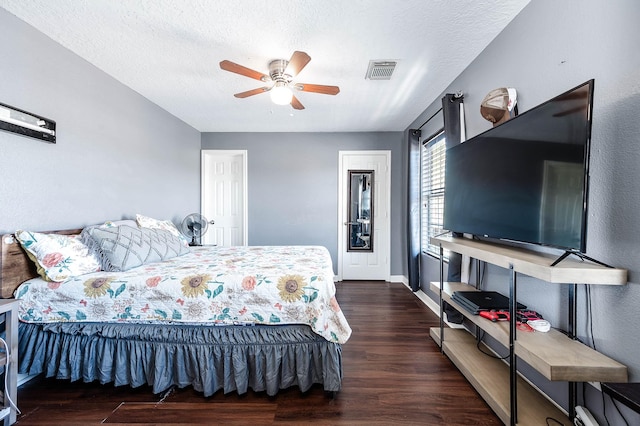 bedroom featuring visible vents, a ceiling fan, a textured ceiling, wood finished floors, and baseboards