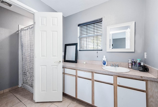 bathroom featuring visible vents, curtained shower, tile patterned flooring, a textured ceiling, and vanity