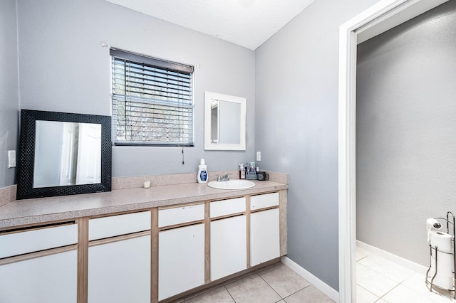 bathroom featuring tile patterned flooring, vanity, and baseboards