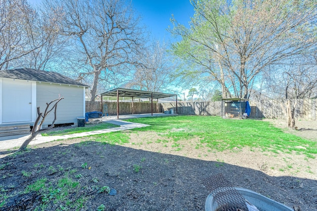 view of yard featuring an outbuilding, a fenced backyard, and a storage unit