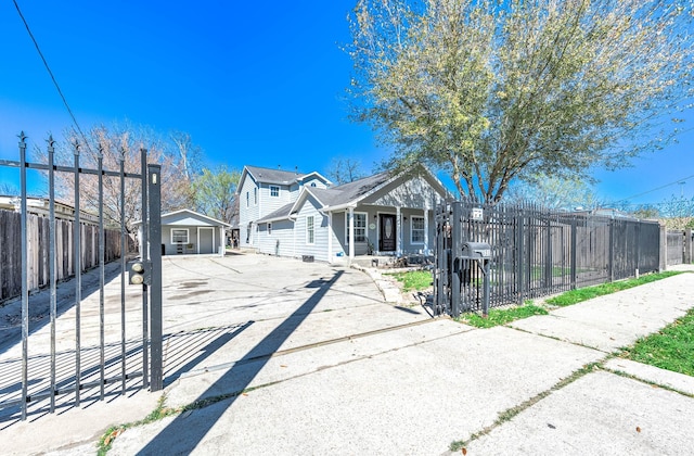 view of front of house with concrete driveway and a fenced front yard