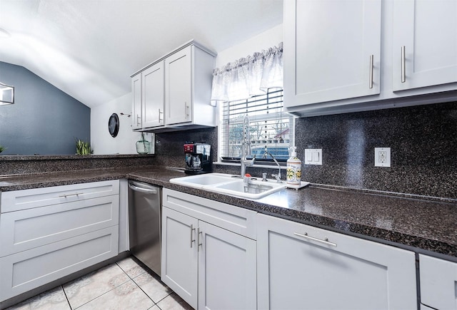 kitchen featuring light tile patterned floors, lofted ceiling, stainless steel dishwasher, decorative backsplash, and a sink