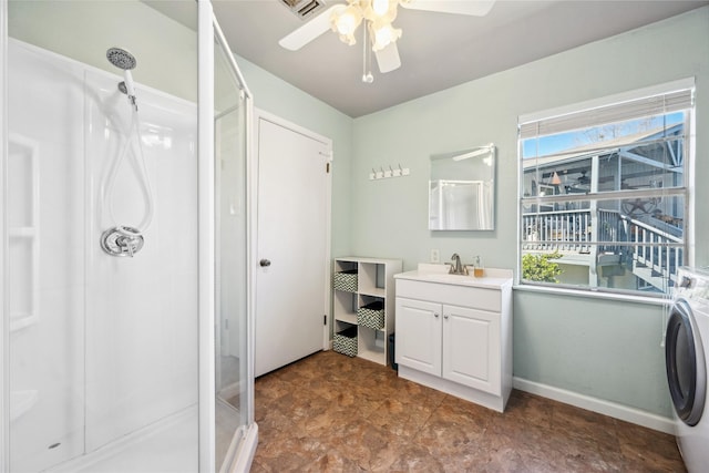 bathroom with vanity, baseboards, washer / clothes dryer, ceiling fan, and a shower stall