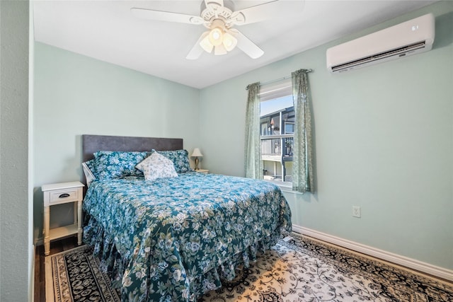 bedroom featuring a ceiling fan, baseboards, a wall mounted AC, and wood finished floors