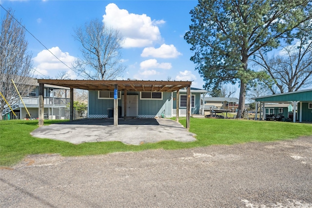 back of house with a yard, driveway, and board and batten siding