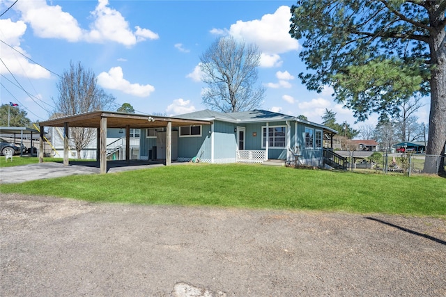 view of front of property featuring fence, a front lawn, and aphalt driveway