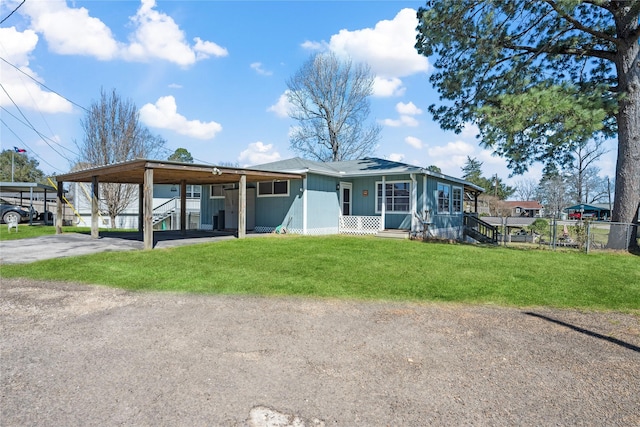 view of front of home with an attached carport, fence, and a front lawn