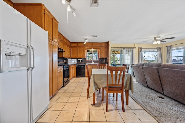 kitchen featuring visible vents, under cabinet range hood, black appliances, and a wealth of natural light