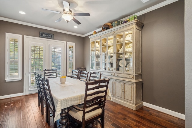 dining space with ornamental molding, baseboards, and dark wood-style floors