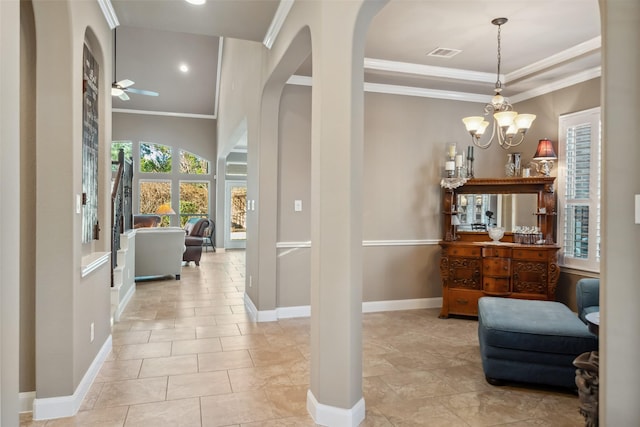 hallway featuring arched walkways, a notable chandelier, visible vents, baseboards, and ornamental molding