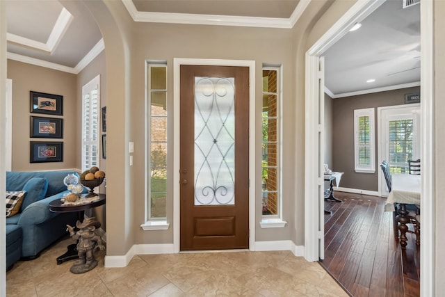 foyer with arched walkways, recessed lighting, visible vents, baseboards, and ornamental molding