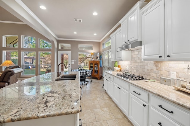 kitchen featuring stainless steel gas cooktop, visible vents, ornamental molding, a sink, and under cabinet range hood