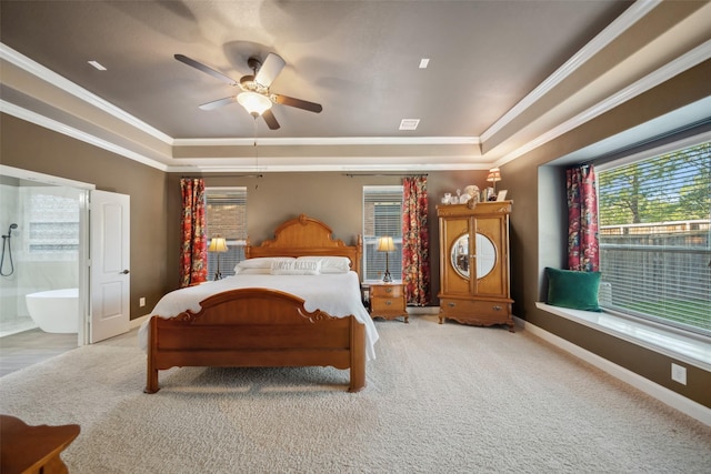 carpeted bedroom featuring ornamental molding, a raised ceiling, ensuite bath, and baseboards